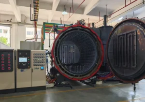 Industrial horizontal vacuum annealing furnace with open door and digital control panel in a factory setting.