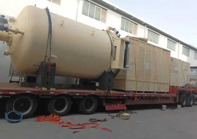 Completed vacuum furnace equipment loaded on a long-bed trailer for export shipment to Russia