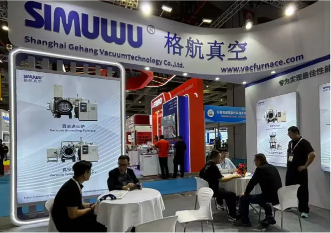 SIMUWU specialists discussing mold vacuum heat treatment processes with business partners at the exhibition booth